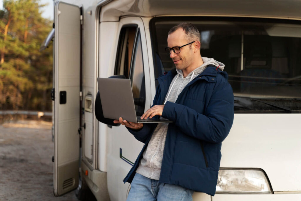 A man using laptop with a van